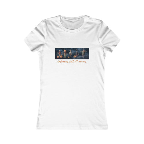 A white short-sleeve crewneck t-shirt with a horizontal graphic print on the chest depicting harvest scarecrows in Halloween costumes, with 'Happy Halloween' written in orange cursive below them. ancient harvest energy with lots of cozy cottage vibes