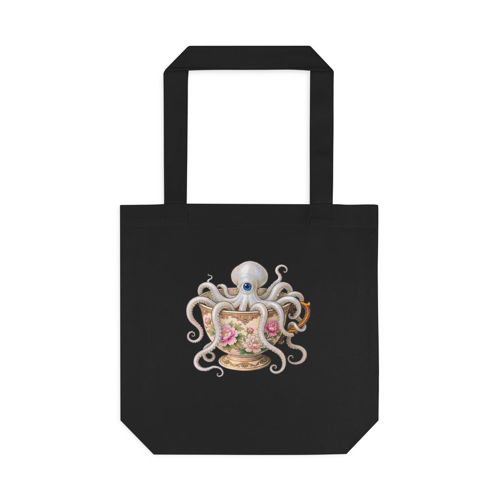 A black canvas tote bag with a graphic of an octopus sitting in a delicate victorian teacup. looks very  cottage friendly for lovers of kitchen magic and cozy looks