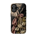 A protective phone case featuring a cottage aesthetic Victorian style classical painting print of a hand holding a bouquet of dried flowers and a pink ribbon, shown on a a dark moody background. 